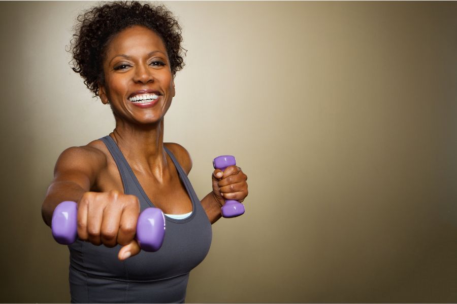 lady with dumbells smiling